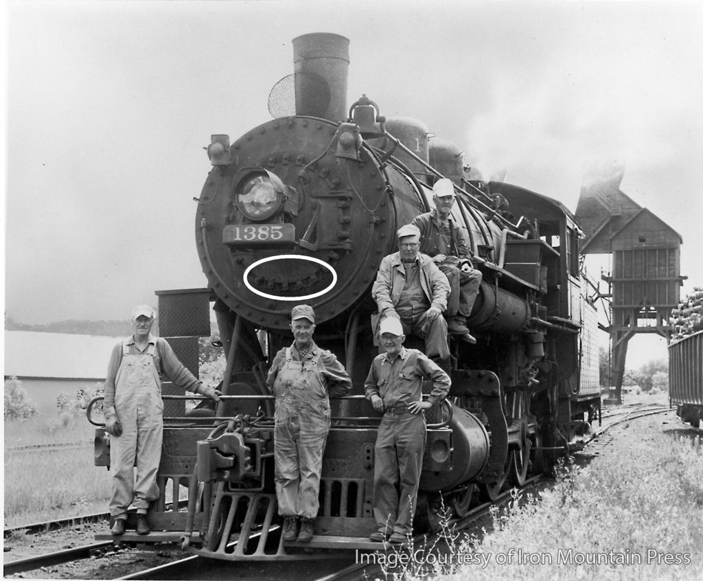 historic photo of locomotive number 1385 and crew with circle highlighting location of door dogs on front of locomotive